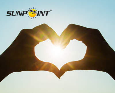 Zwei Hände bilden Herz um die Sonne